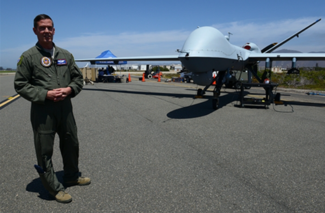 Air Force Maj. Scott Gregg, a Black Dart project officer, speaks to the media in front of a MQ-9 unmanned aircraft system, at Naval Base Ventura County and Sea Range, Point Mugu, Calif.